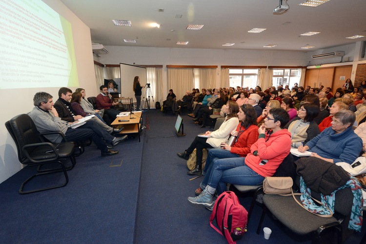 Auditorio con público sentado en sillas y expositores en la mesa de apertura